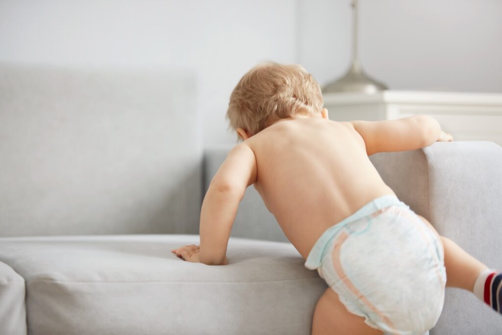 Baby climbing onto couch
