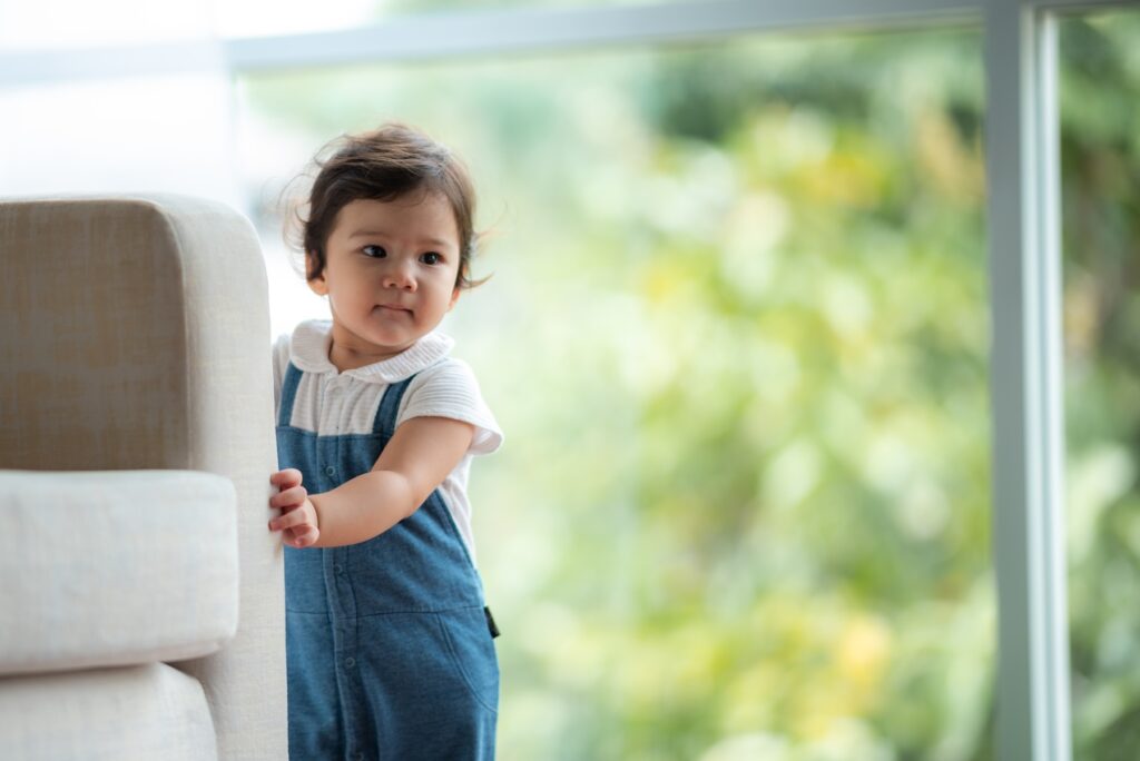 cute baby holding onto couch