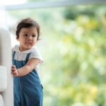 cute baby holding onto couch